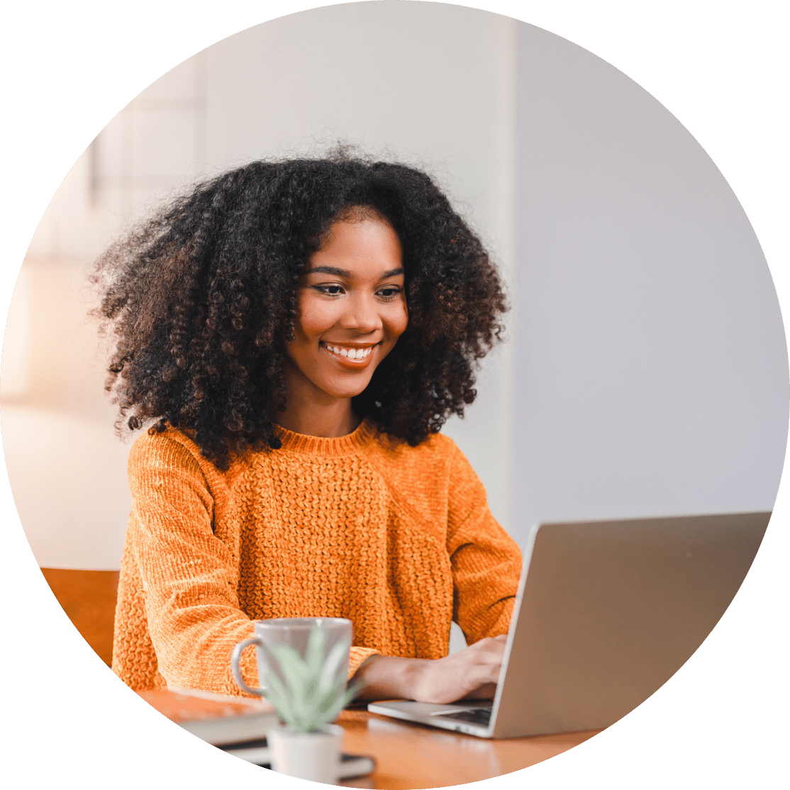 A woman smiling and typing on a laptop