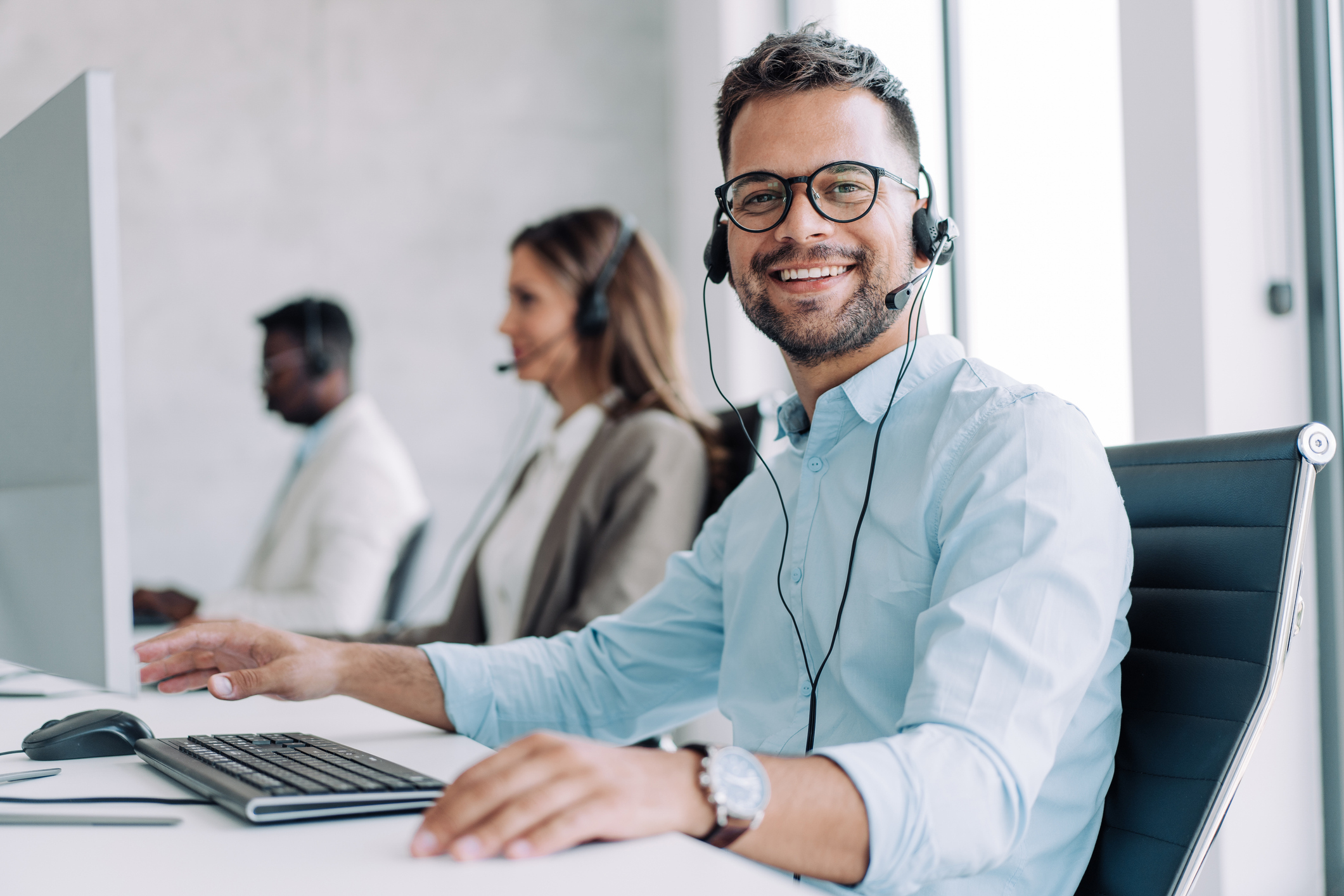 A man sitting at a desk with a headset