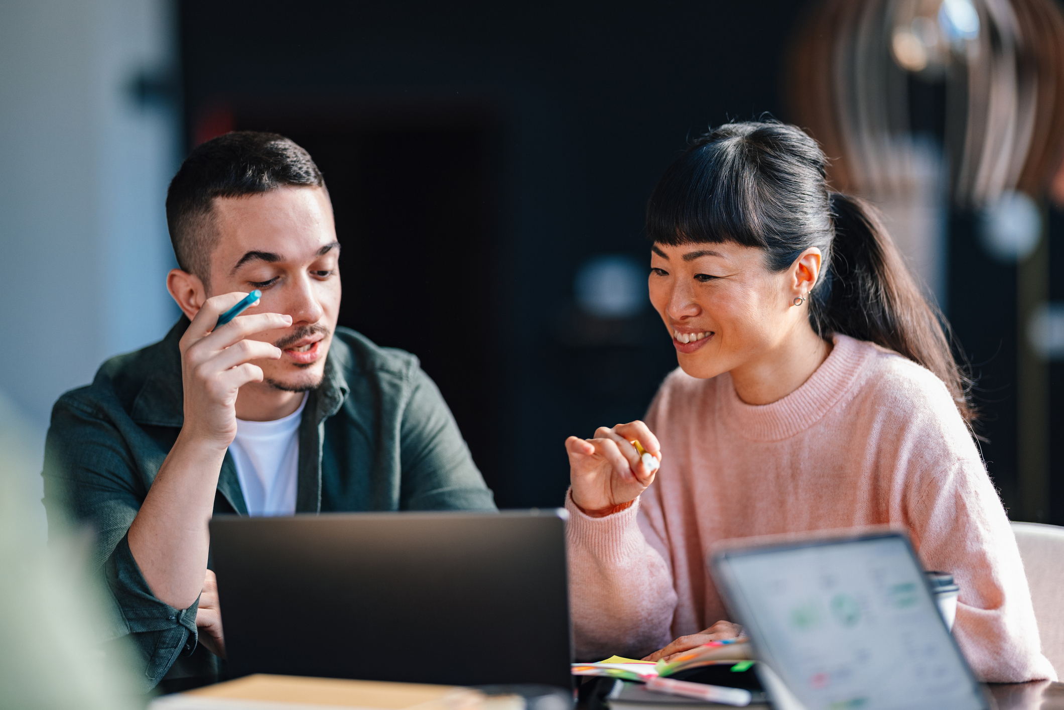 A man and woman collaborating at a desk