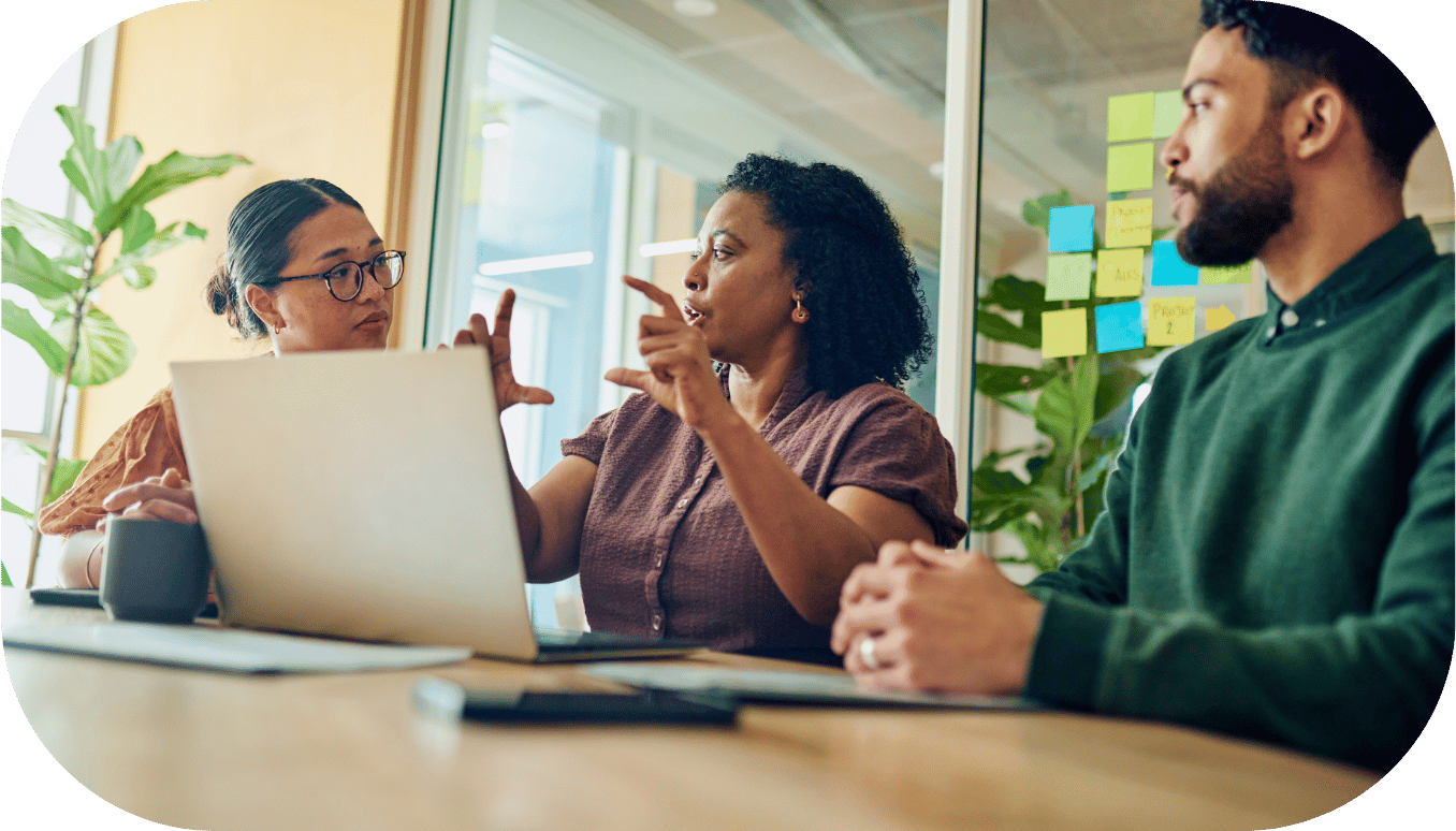 Three coworkers discussing around a laptop
