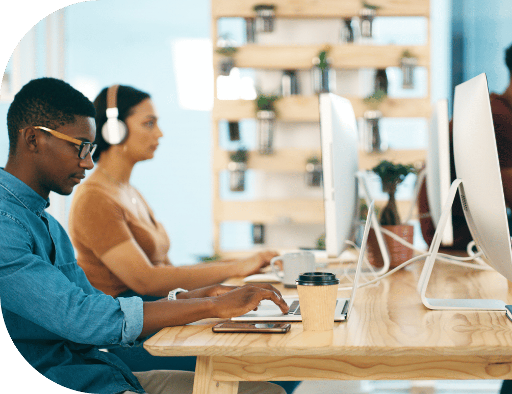 Two people typing at a desk
