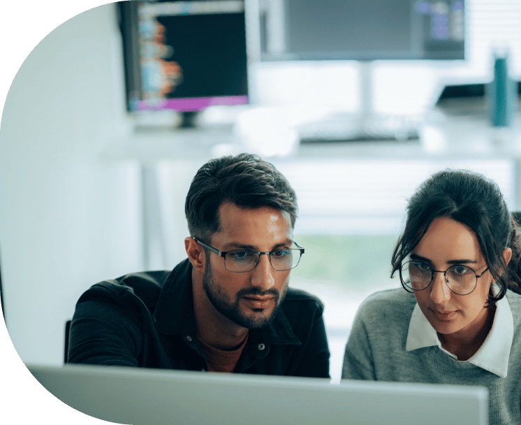 Two coworkers looking at a computer screen