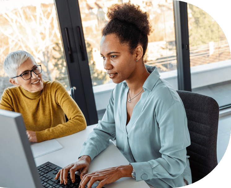 Two coworkers looking at a desktop