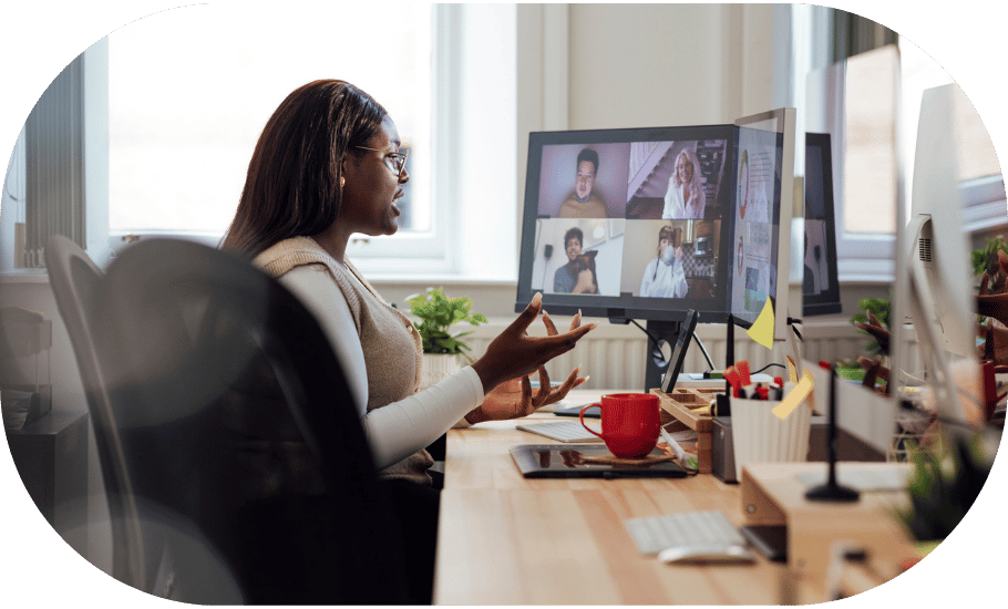A woman on a virtual meeting at her desk