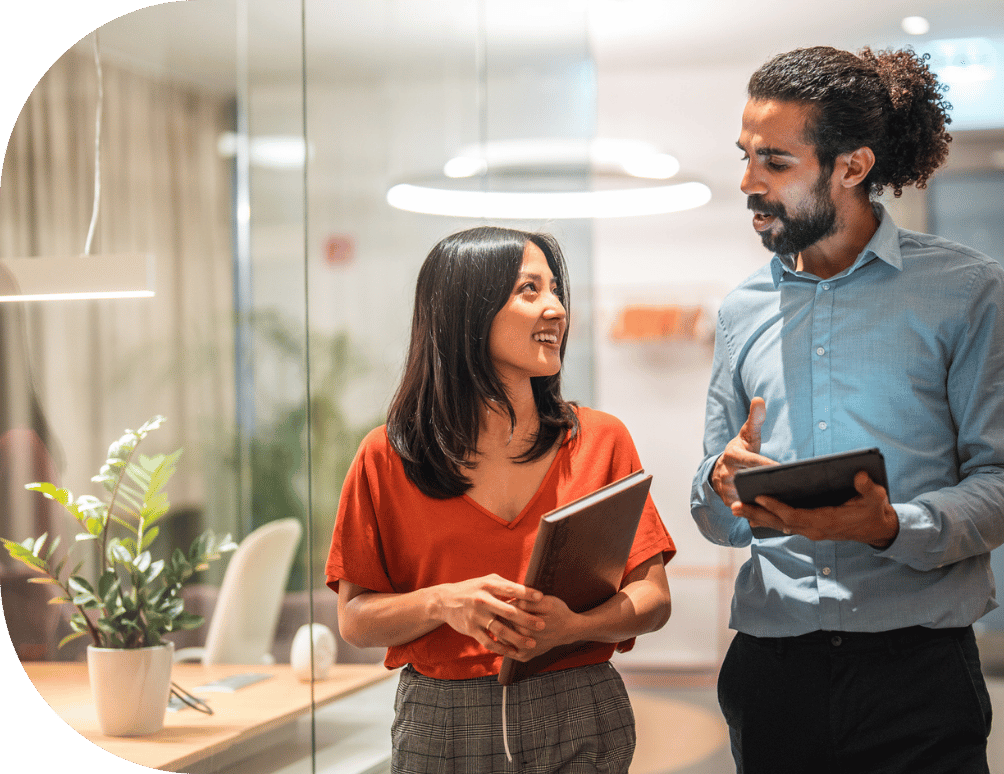 Two people walking and talking in an office