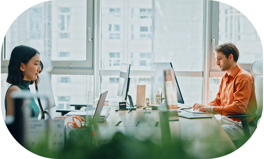 Two people typing at a desk