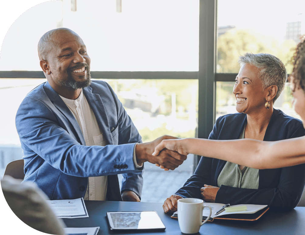 Two people shaking hands at a table