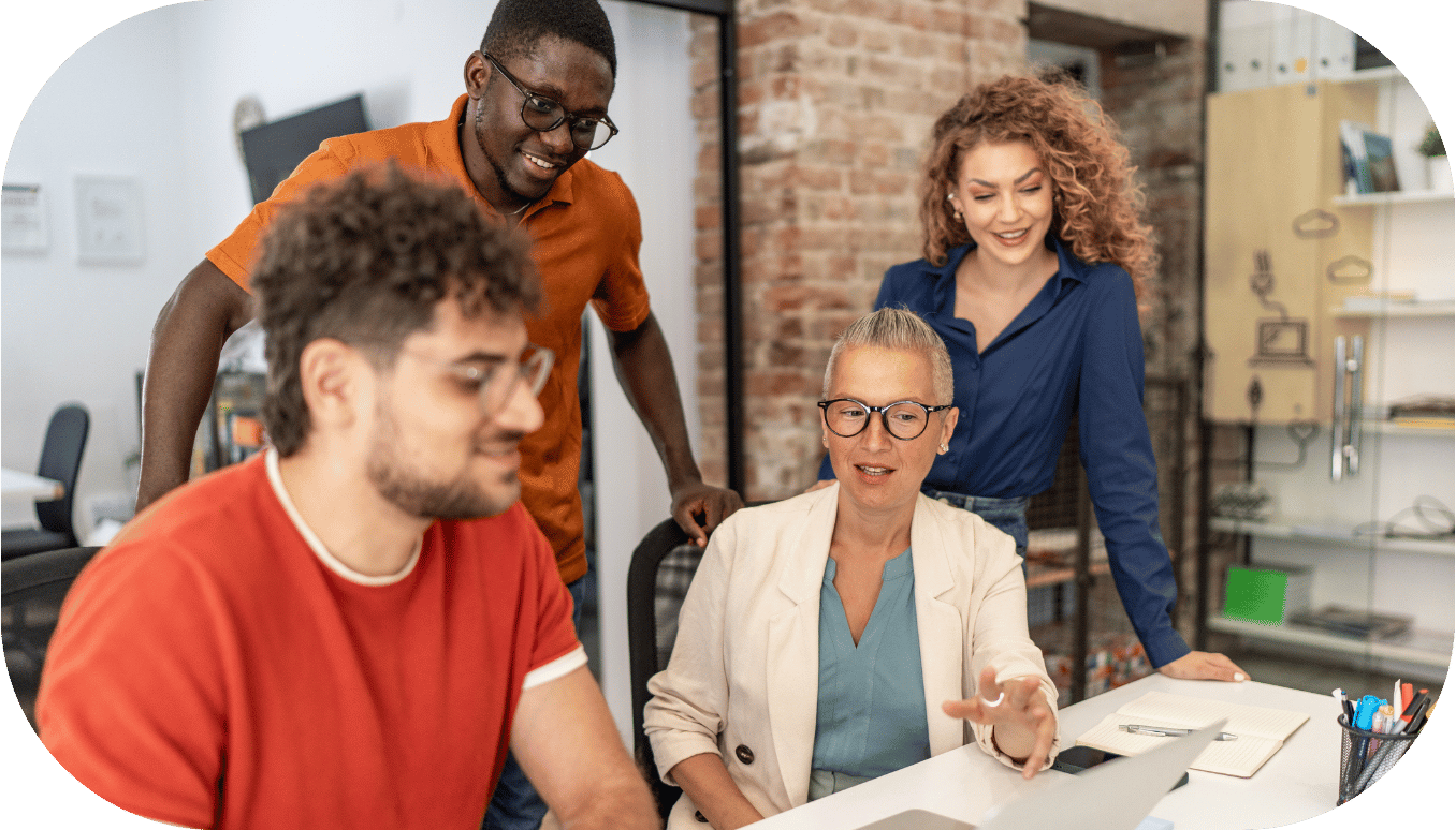 Four coworkers having a discussion around a laptop