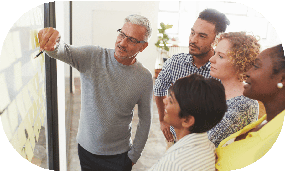 Man pointing to discussion board with a group