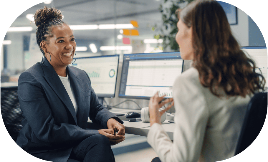 Two coworkers talking at a desk