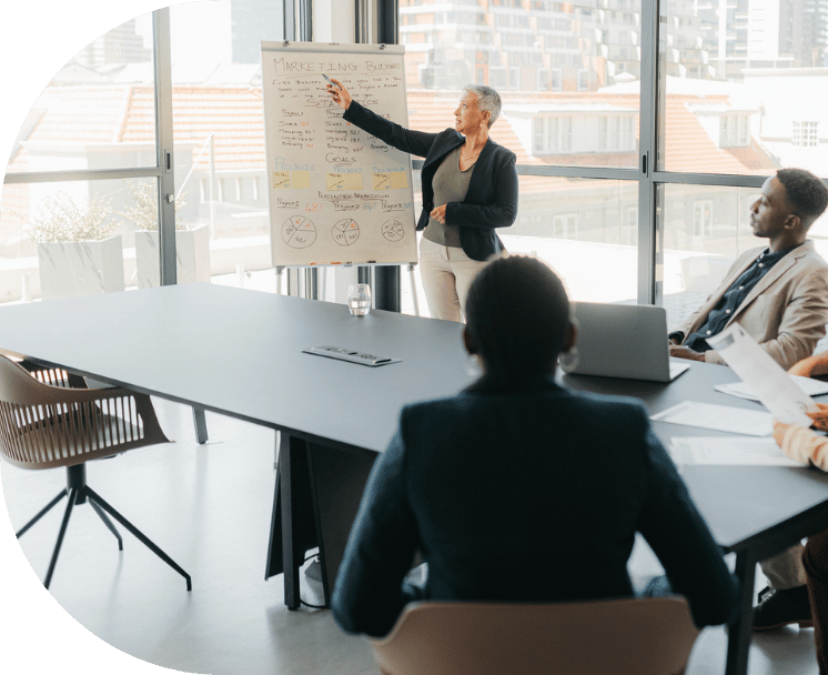 A woman presenting and pointing to a chart